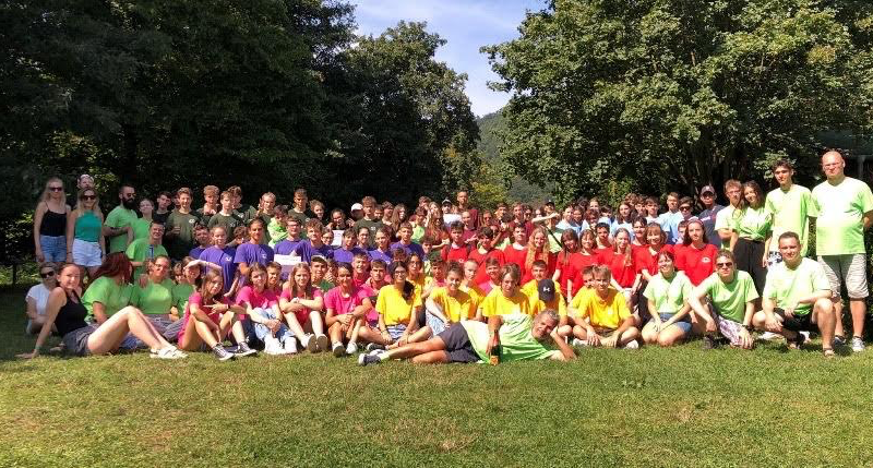 A group of people in colorful shirts Description automatically generated