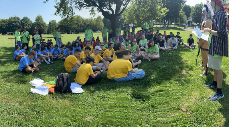 A group of people sitting on the grass Description automatically generated